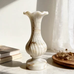 Cream marble vase with spiral ribbed design on table, natural stone decorative piece for modern interiors